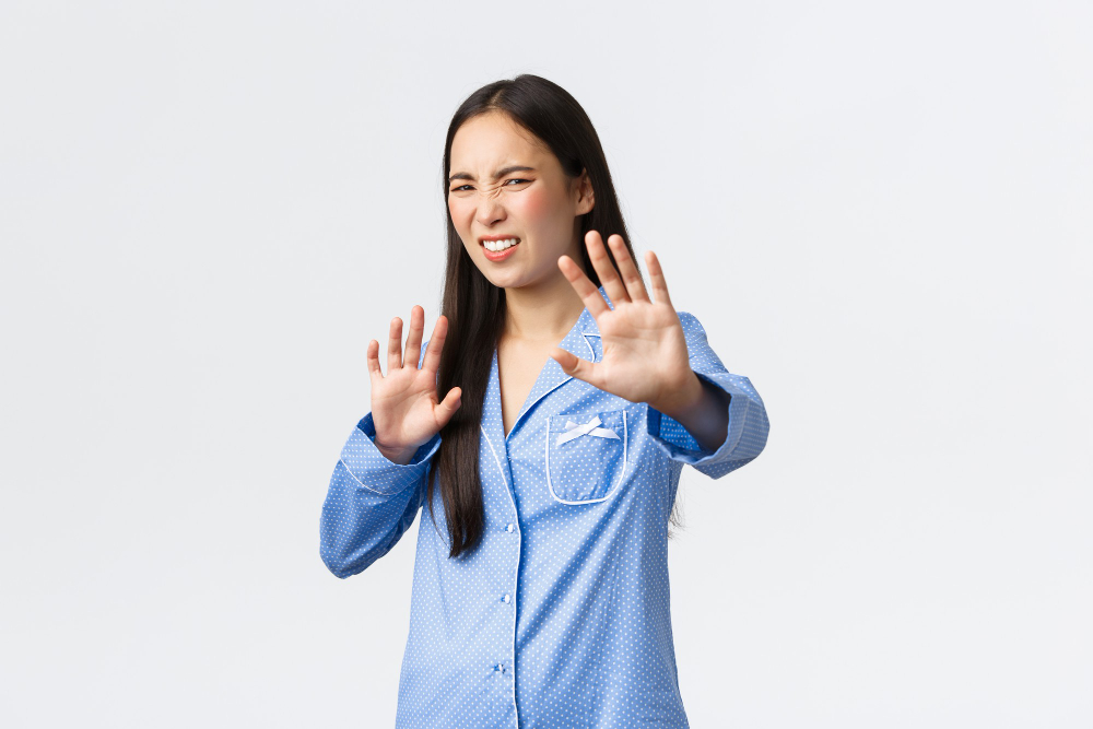 digusted-and-displeased-asian-girl-in-blue-pajamas-extend-hands-forward-in-refusal-rejecting-something-disgusting-grimacing-from-aversion-and-dislike-shaking-hands-in-denial-over-white-background.jpg