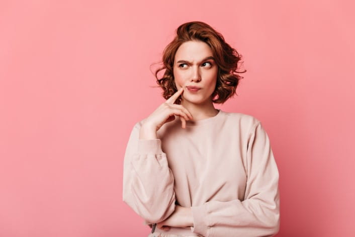 front-view-of-pensive-pretty-woman-curly-girl-thinking-on-pink-background_(2).jpg