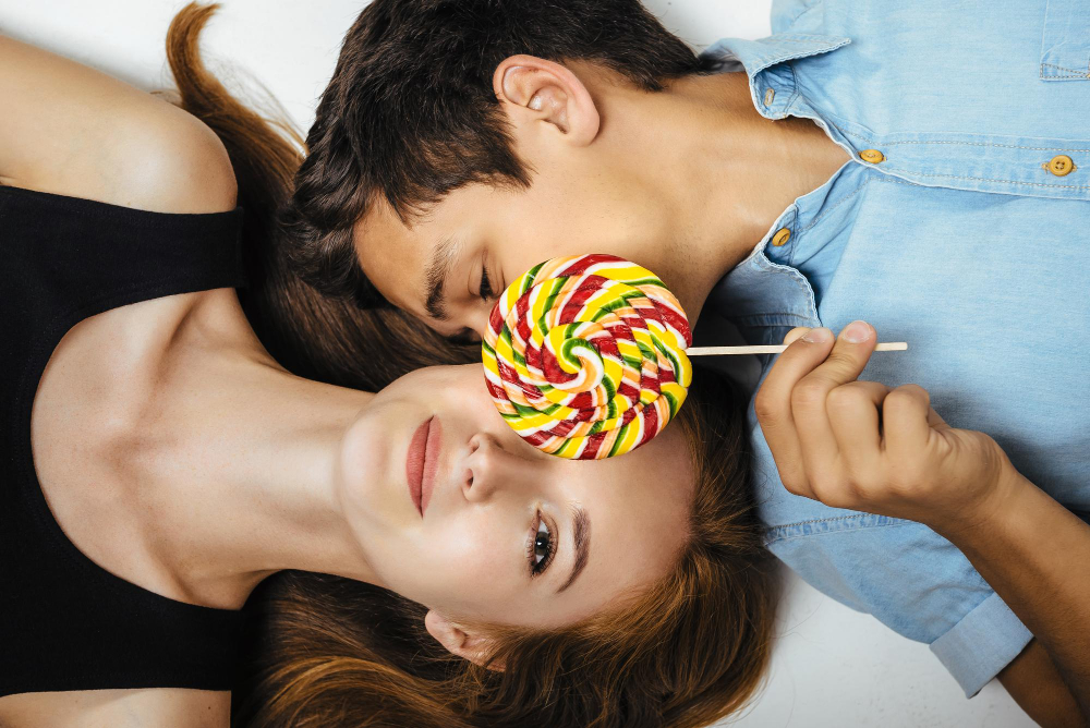 lovers-lie-on-the-floor-covering-her-face-with-colored-lollipop.jpg