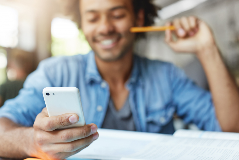 people-lifestyle-technology-and-communication-concept-handsome-bearded-dark-skinned-male-student-wearing-blue-shirt-using-cell-phone-browsing-newsfeed-via-social-networks-laughing-at-memes.jpg